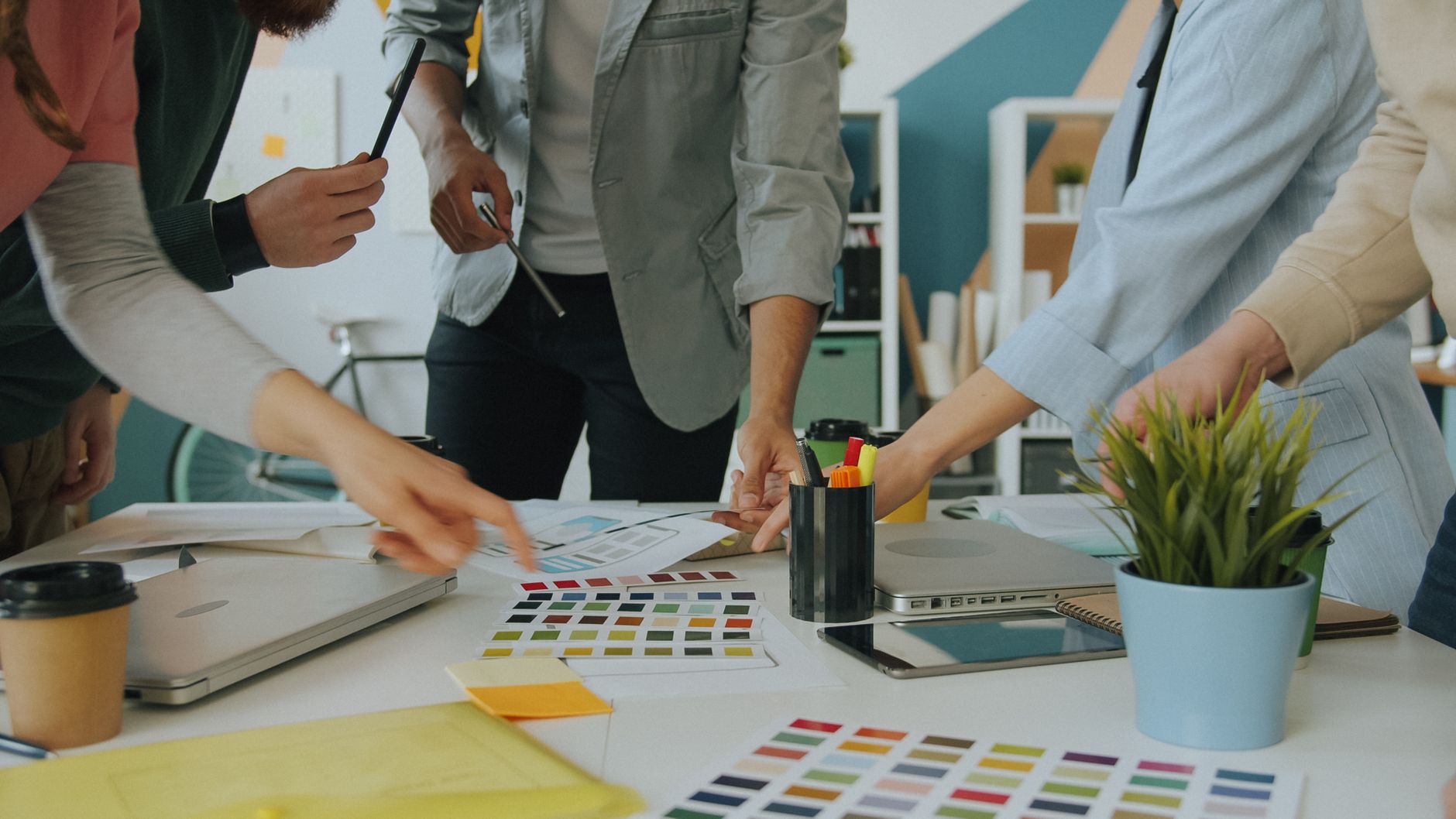 Team arbeitet an einem Tisch mit Farbmustern und Gestaltungselementen an einem Designprojekt