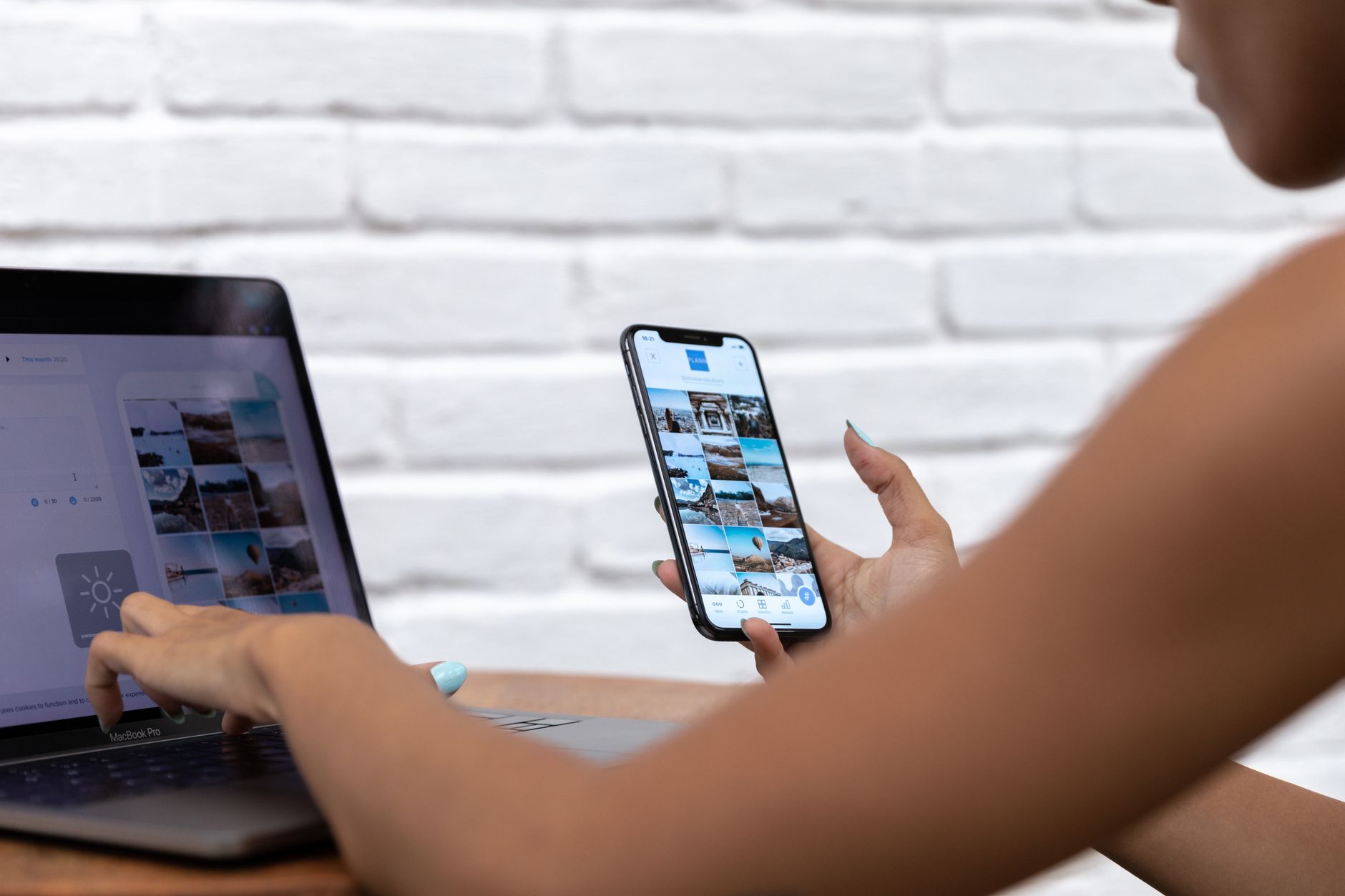 Frau betreut Social-Media-Inhalte gleichzeitig an Laptop und Smartphone