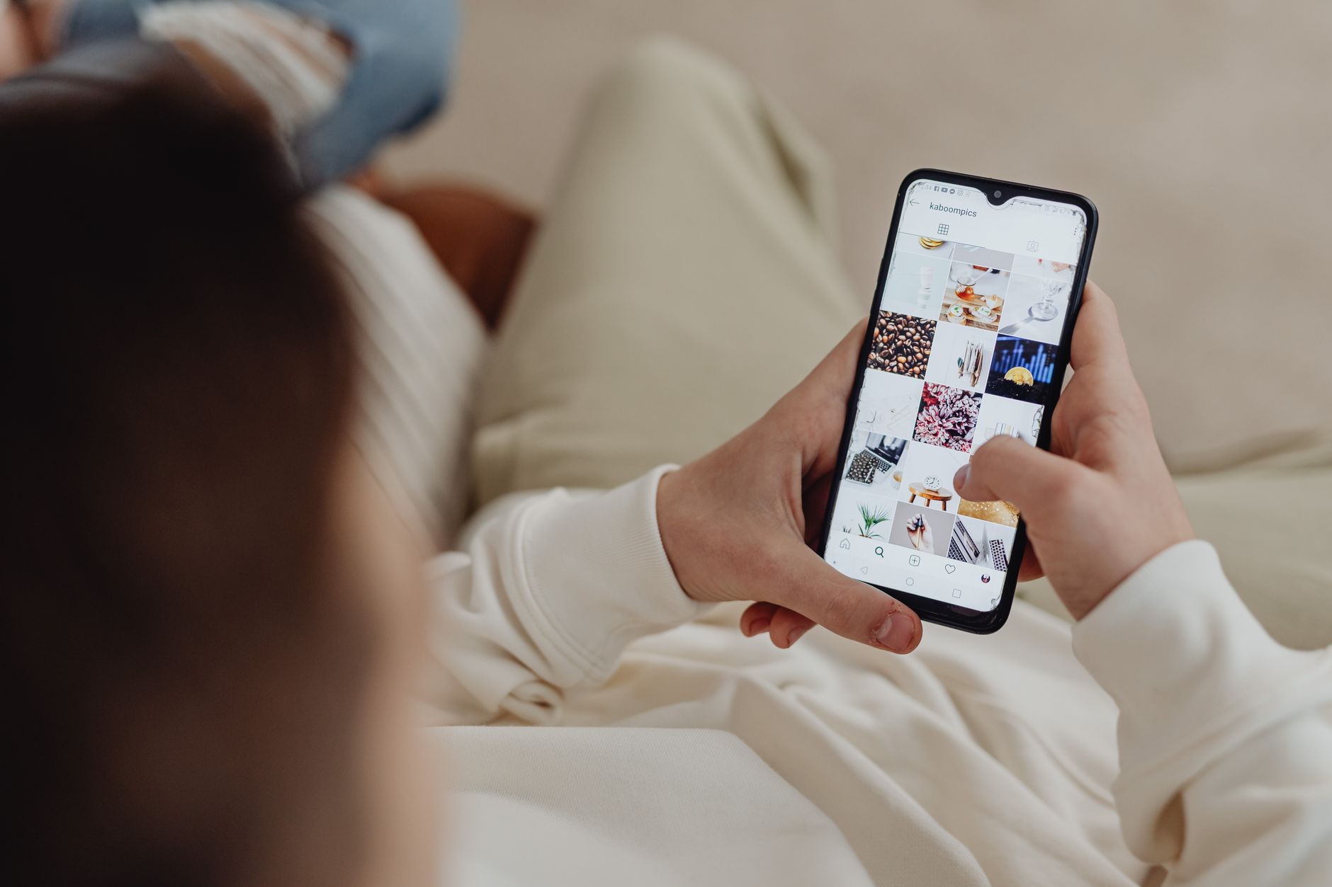 Person blättert auf dem Smartphone durch Beiträge im Instagram-Feed